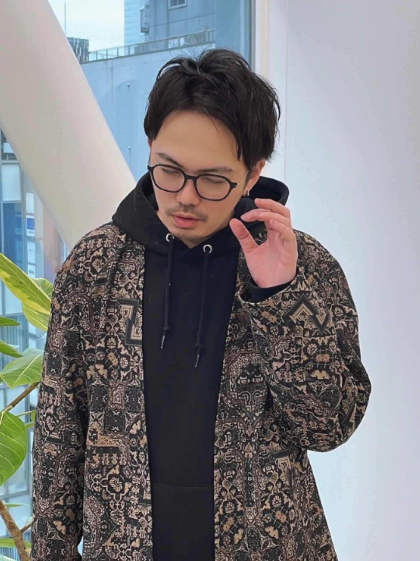オーナーの渋谷トモヒロ。眼鏡をかけ、柄物のジャケットに黒のパーカーを着ている