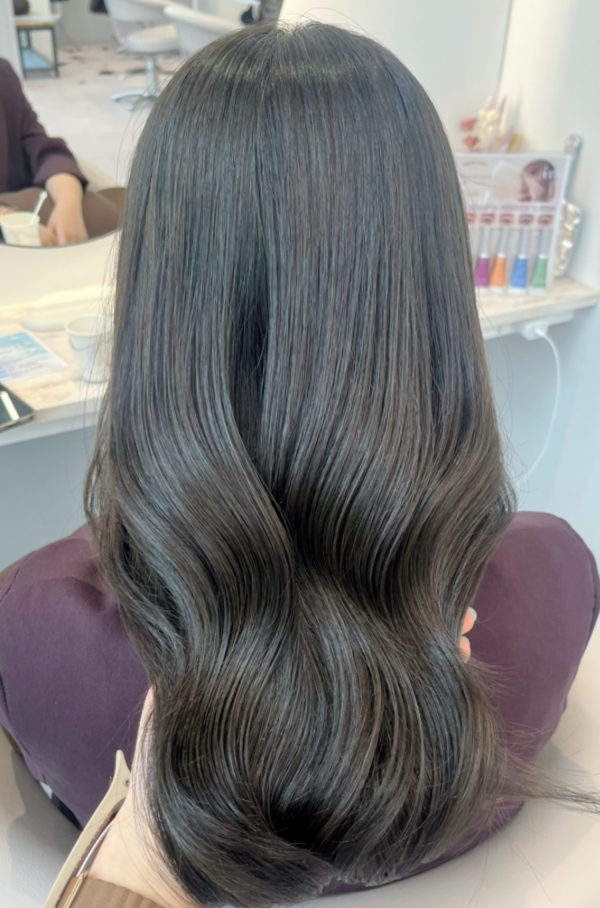 シークレットハイライトのロングヘアを後ろから見たところ。落ち着いたカーキ系の髪色に、ツヤと透明感が出ている