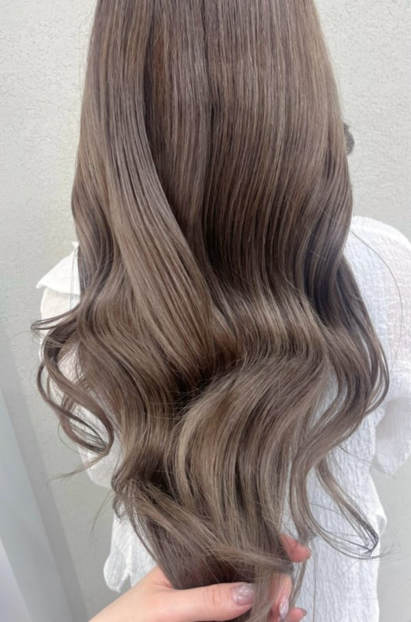 シークレットハイライトのロングヘアを後ろから見たところ。明るめのベージュの髪色に、ツヤと透明感が出ている