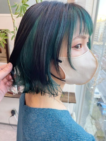 アンブレラカラーのエメラルドグリーン。表面の暗髪の下から、内側のエメラルドグリーンがのぞいている